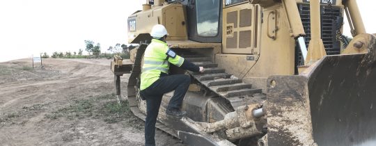 Man climbing onto construction equipment